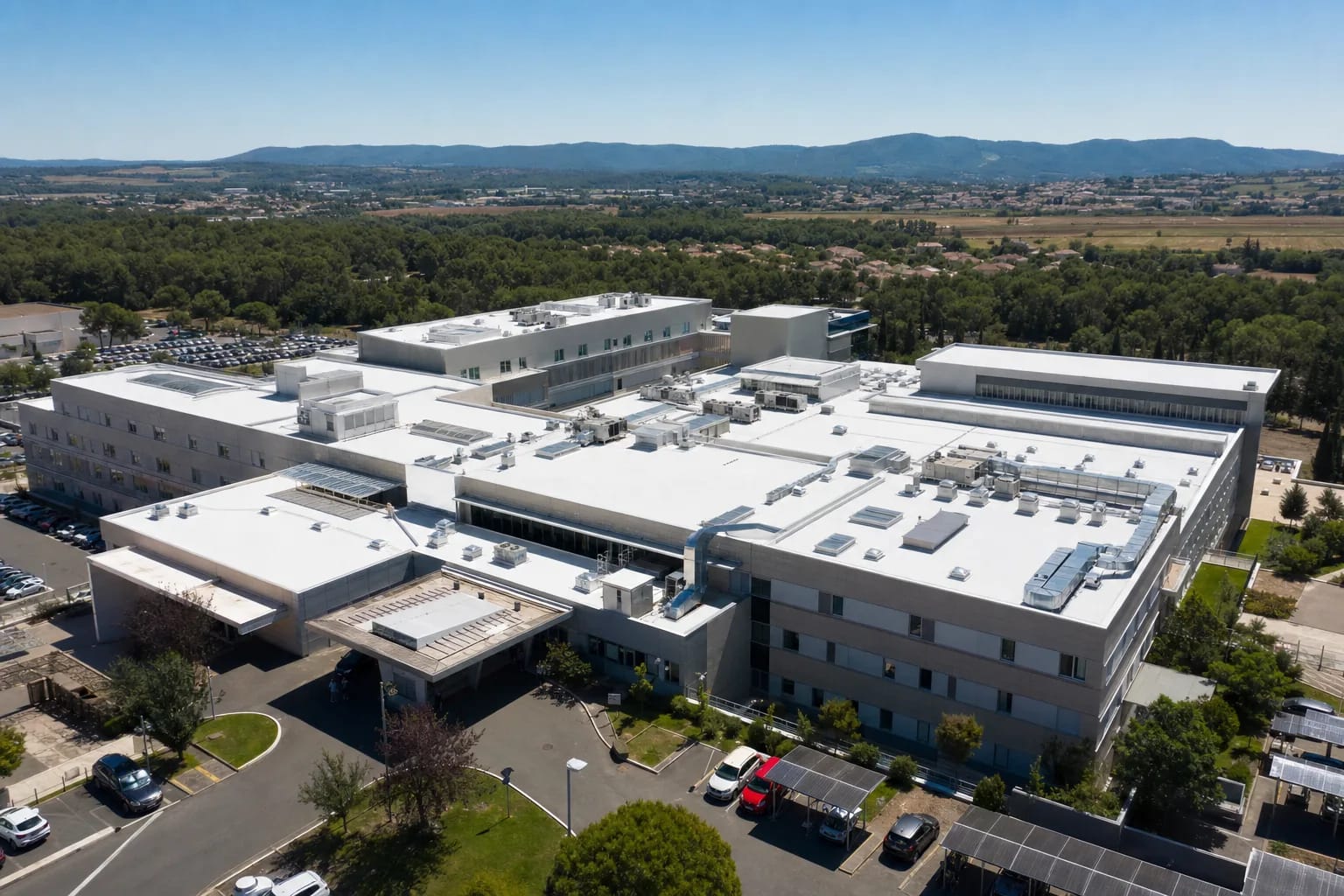 Toiture plate blanche réfléchissante sur un bâtiment hospitalier en été