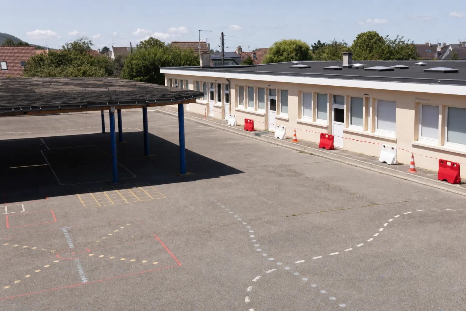 Cour d’école vide pendant les vacances scolaires avec accès chantier balisé